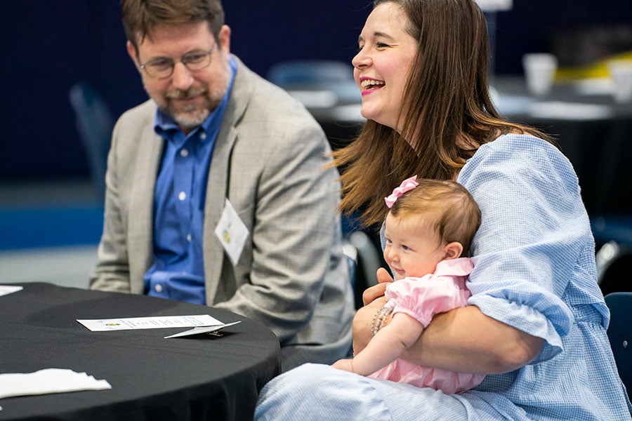 Light of Christ recipient Jill Foley shares a laugh as she holds her baby daughter during the Light of Christ Parish Stewardship Awards on June 24, 2023 at Holy Family Church.
